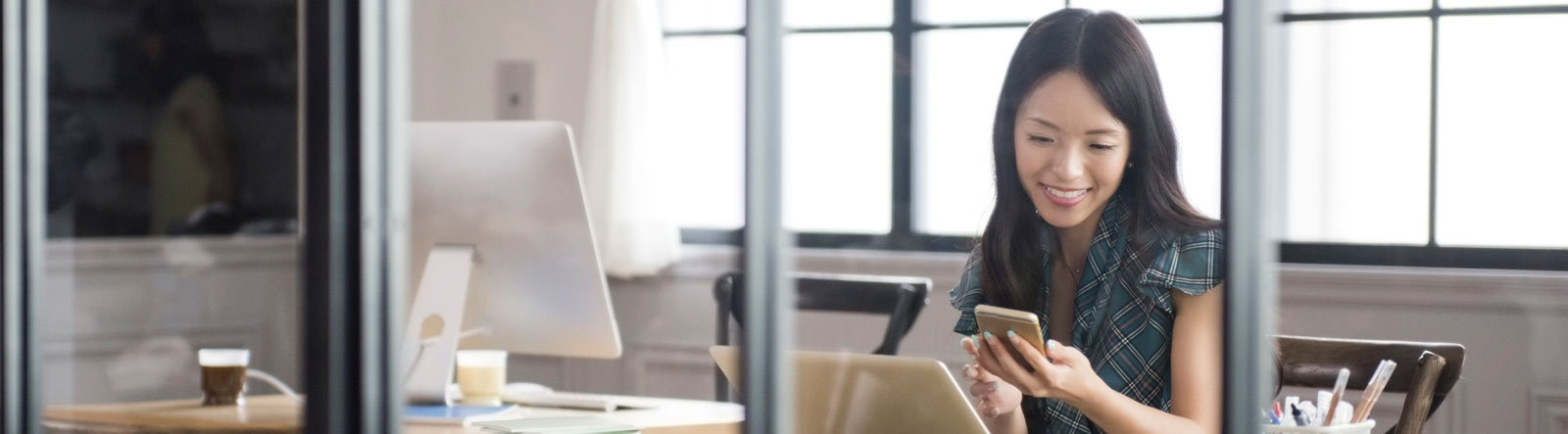 Woman looking at phone in office.