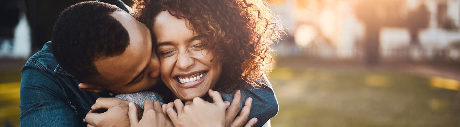 Happy young adult couple hugging.