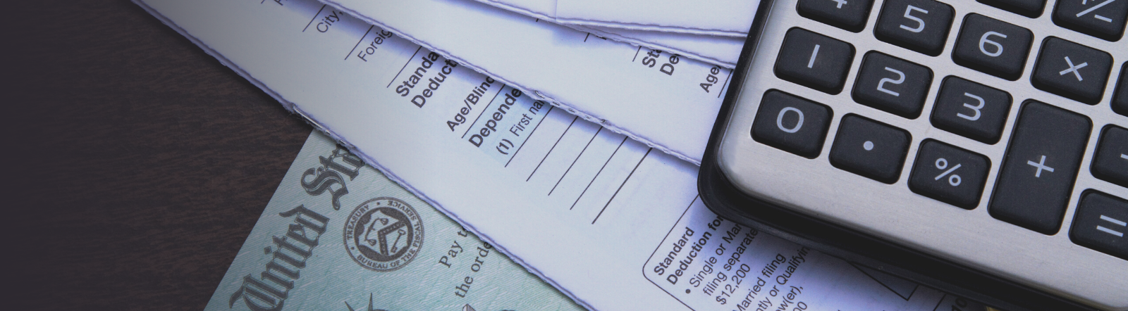 stack of IRS papers topped with a calculator