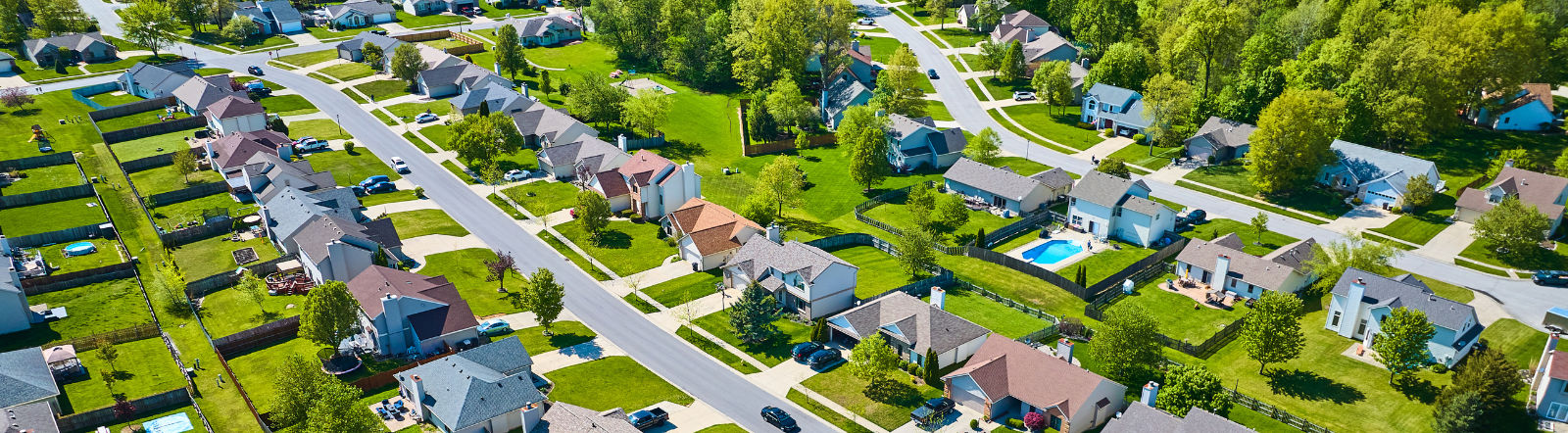 aerial shot of dozens of homes in a suburb on a sunny day