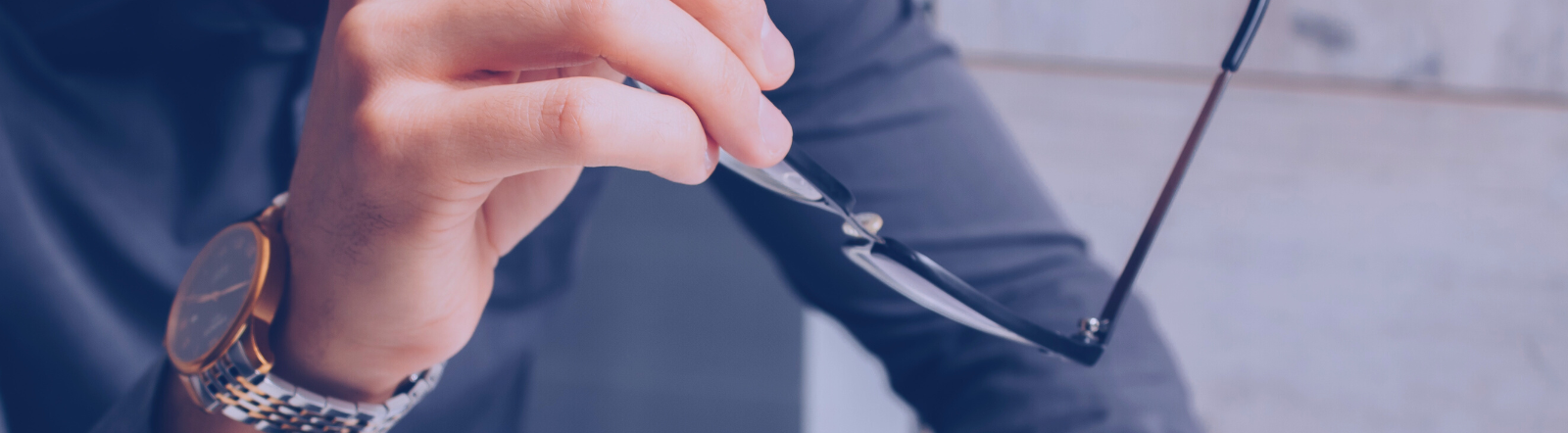 man wearing watch holding glasses