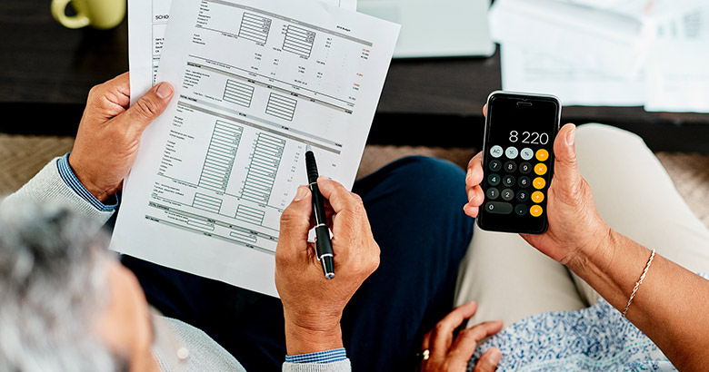 Couple looking at papers and calculator.