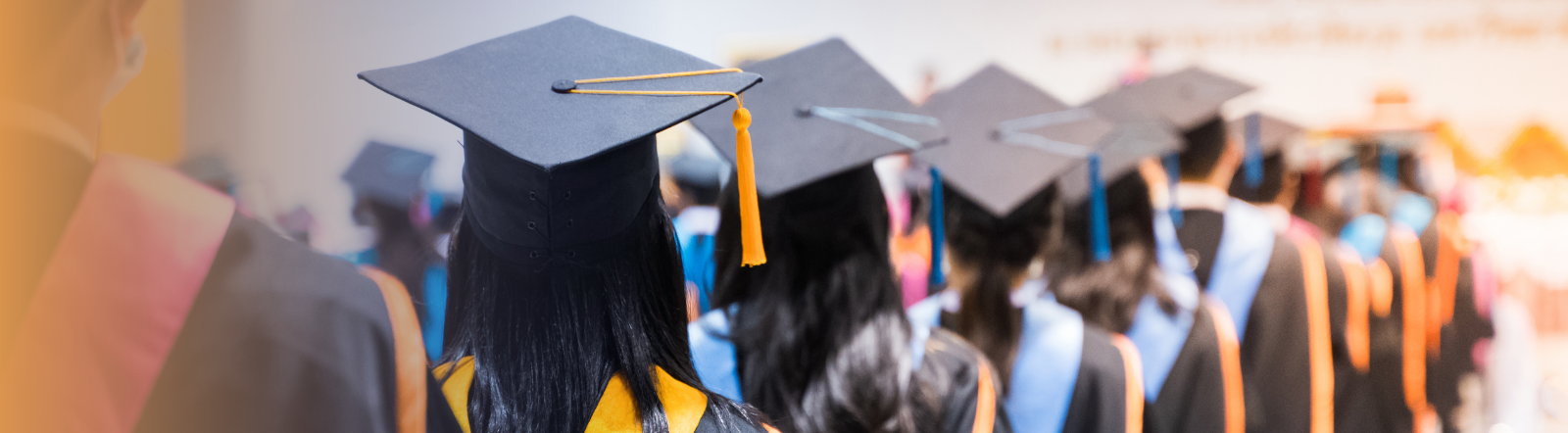 a large group of graduates wearing cap and gowns stand together