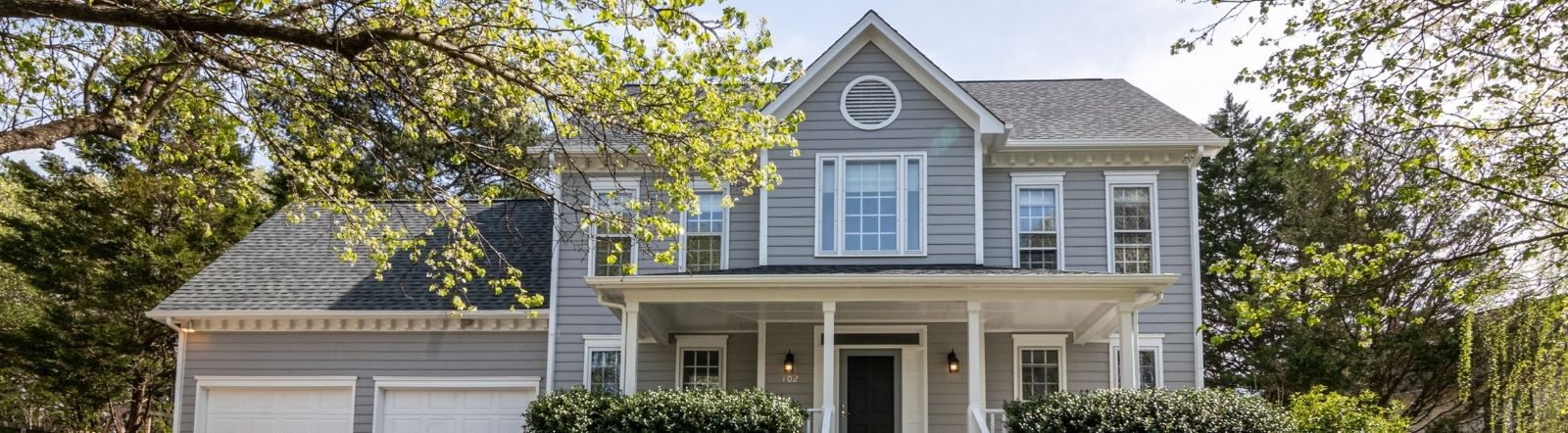 large gray home on summer day