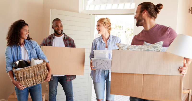 two couples moving boxes into home