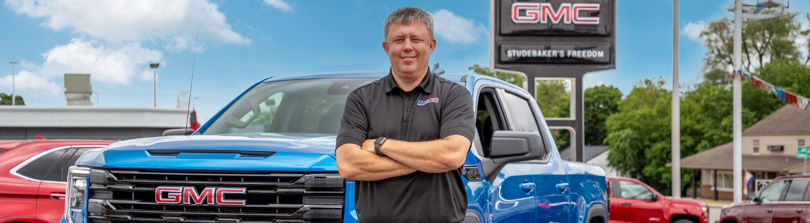 man smiles in front of pickup truck