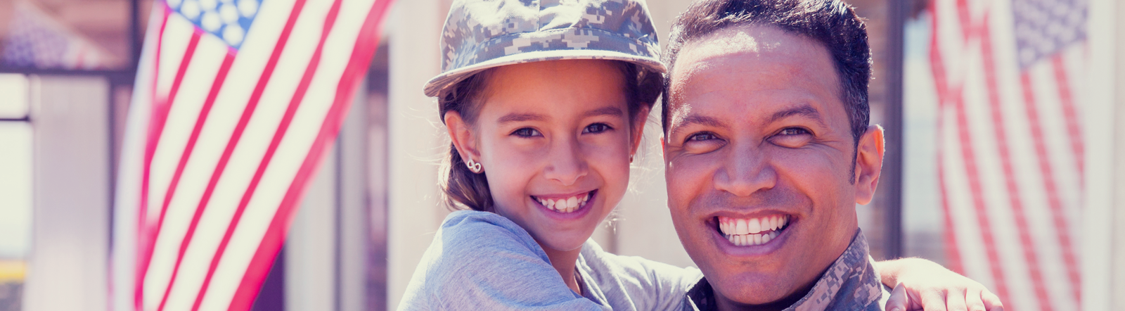 male soldier smiling while holding his daughter