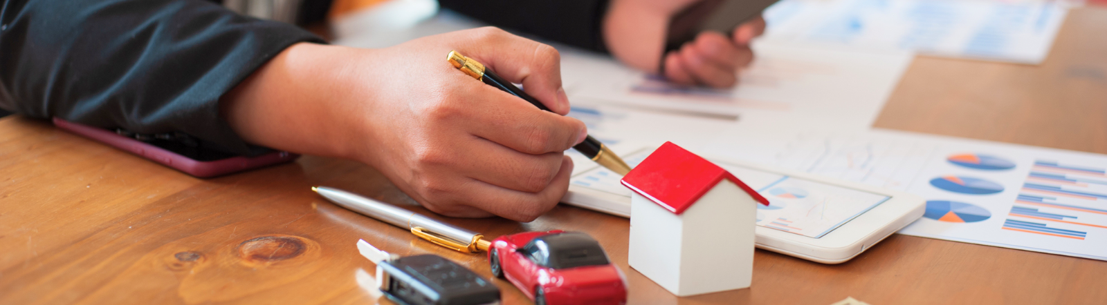 hand holds pen while person analyzes graphs and charts